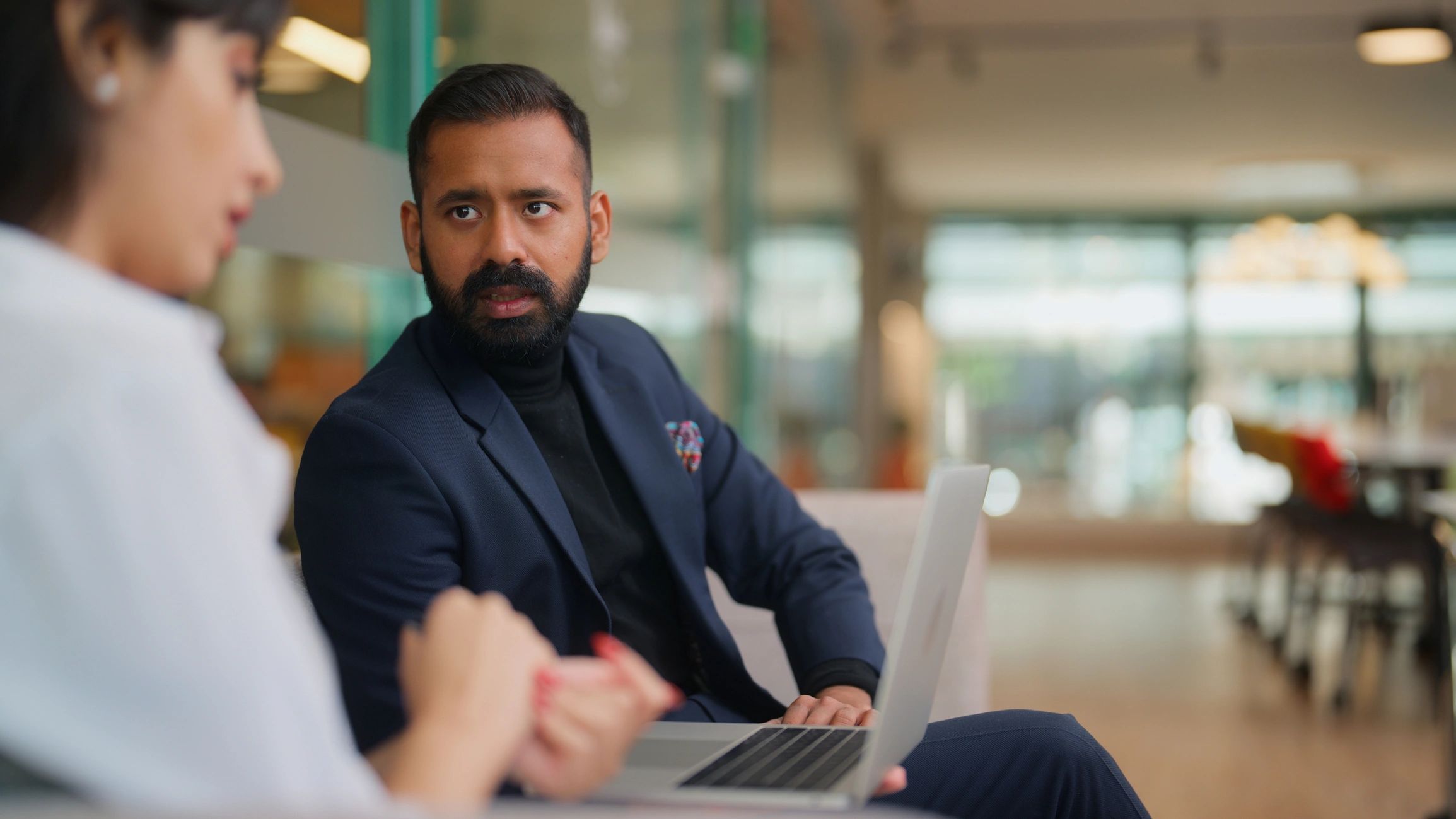 Business professionals collaborating with a laptop in a modern office