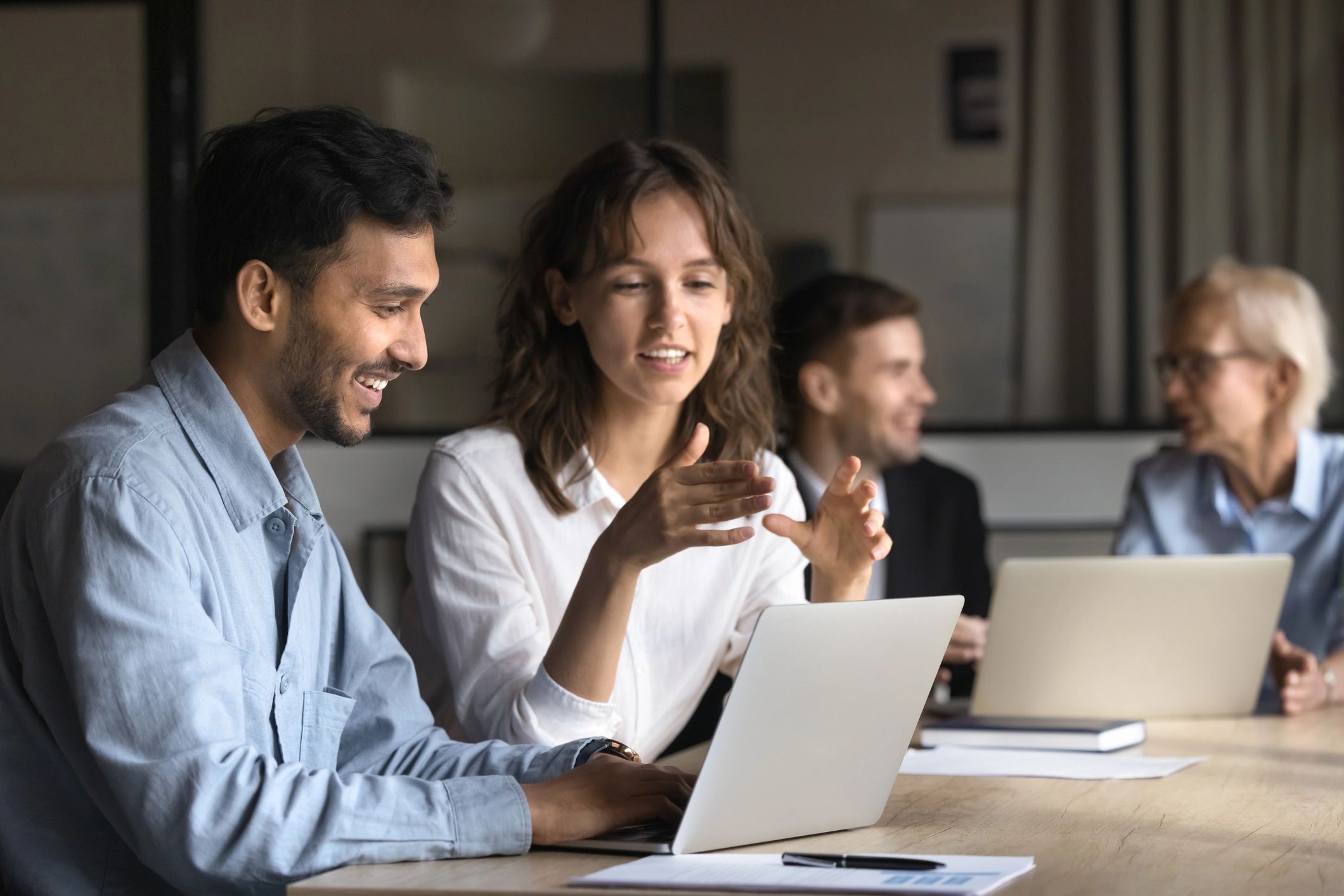 Two project managers collaborating with a laptop in an office